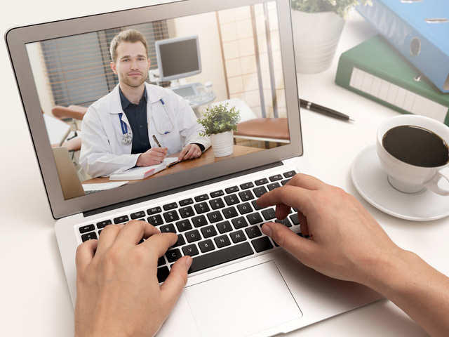 Male doctor on consulting patient through video chat on a laptop computer
