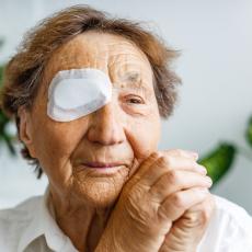 Elderly person wears an eye patch over their right eye post surgery