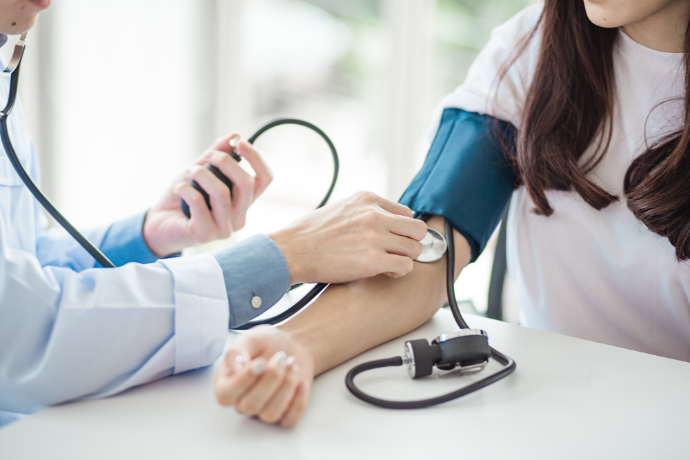 Doctor checks patients food pressure with stethoscope & blood pressure cuff