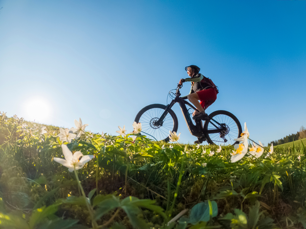 older individual riding a bike actively in the Spring time