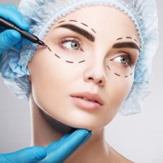 Image of female face with a doctor's hands making lines near eyes for cosmetic surgery.