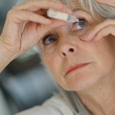 Elderly woman uses eye drops