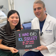 Dr. Silk with EVO ICL surgery patient who are both happy. The happy EVO ICL patient is holding a sign with writing saying "I just had evo icl surgery" and seeing 20/20